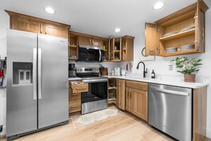 A modern kitchen with stainless steel appliances, wooden cabinets, and a built-in oven.