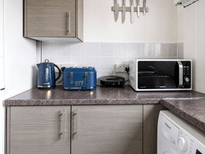 A kitchen with a toaster, kettle, microwave, and a dishwasher. - One Bedroom Luxury Apartment (London)