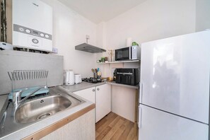 A compact kitchen with a stainless steel sink, a microwave, a toaster, and a refrigerator. - Near Airport - Pets - Parking - WiFi - Sleeps 2 (Hounslow)