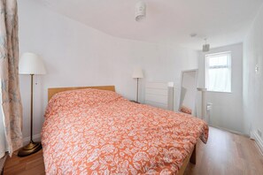 A bedroom with a bed, a floor lamp, a window, and a door. - Near Airport - Pets - Parking - WiFi - Sleeps 2 (Hounslow)