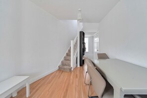 A hallway with a staircase, a white bench, and a white table. - Near Airport - Pets - Parking - WiFi - Sleeps 2 (Hounslow)