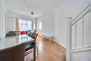 A dining area with a glass table, chairs, a bench, and a staircase. - Near Airport - Pets - Parking - WiFi - Sleeps 2 (Hounslow)