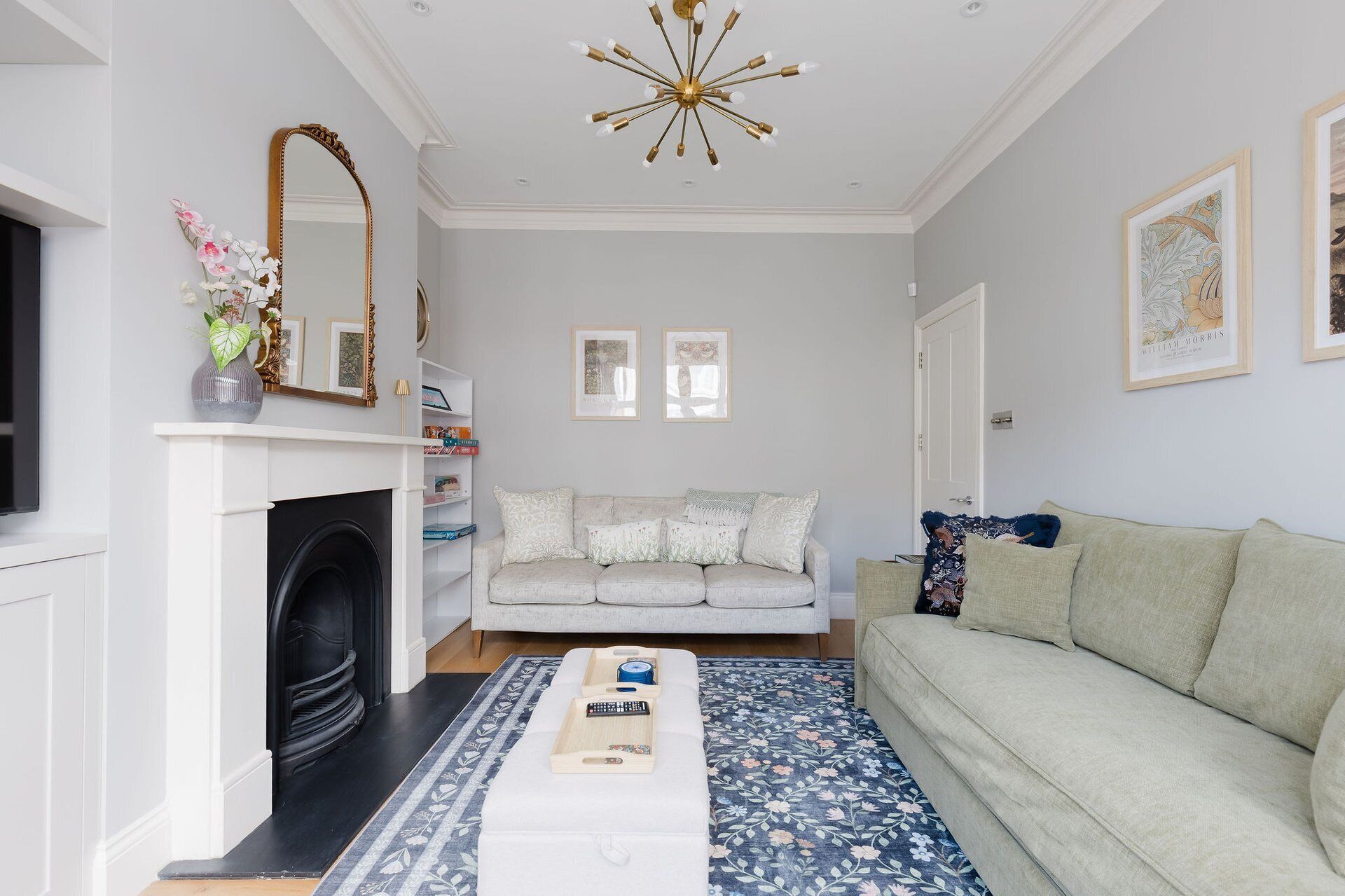 A living room with a fireplace, a sofa, a coffee table, and a chandelier.