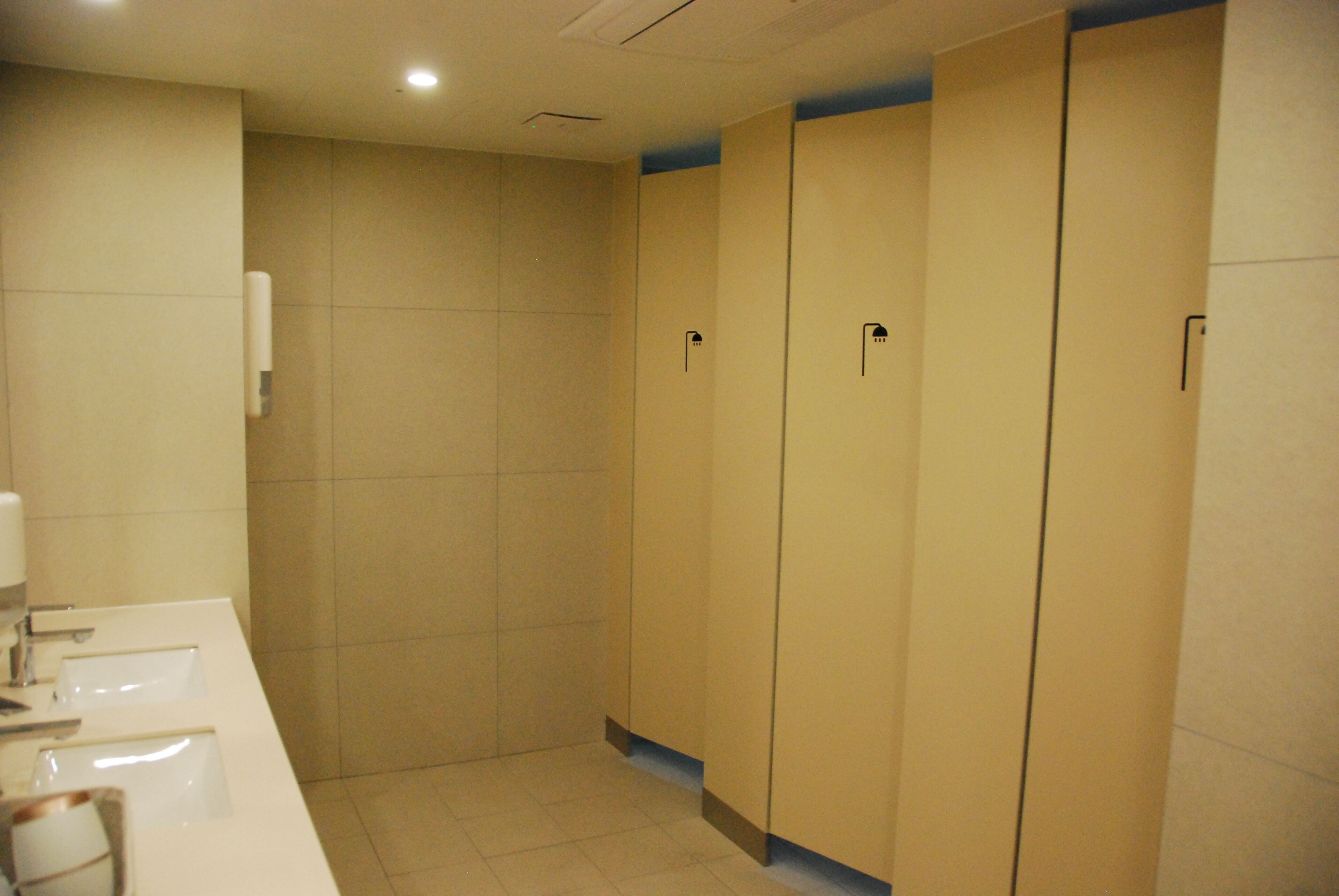 Un baño con un lavabo blanco, un espejo y cuatro armarios de madera.