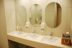 A bathroom with three sinks, mirrors, and soap dispensers. - Good Day Cube Seomyeon Capsule Hotel (Busan)