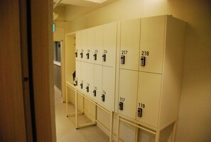 A row of numbered lockers in a hallway. - Good Day Cube Seomyeon Capsule Hotel (Busan)