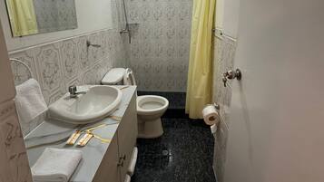 Habitación doble estándar, vista al patio | Baño | Regadera, amenidades de baño gratuitas, secadora de cabello, toallas