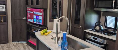 A modern kitchen with a central island, stainless steel appliances, and pendant lighting.
