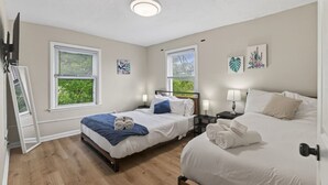 A hotel room with two beds, a window, a ceiling light, and artwork on the walls. - Big Group Getaway Near OSU with 6BR, 8 Beds, 5-Car Parking (Columbus)