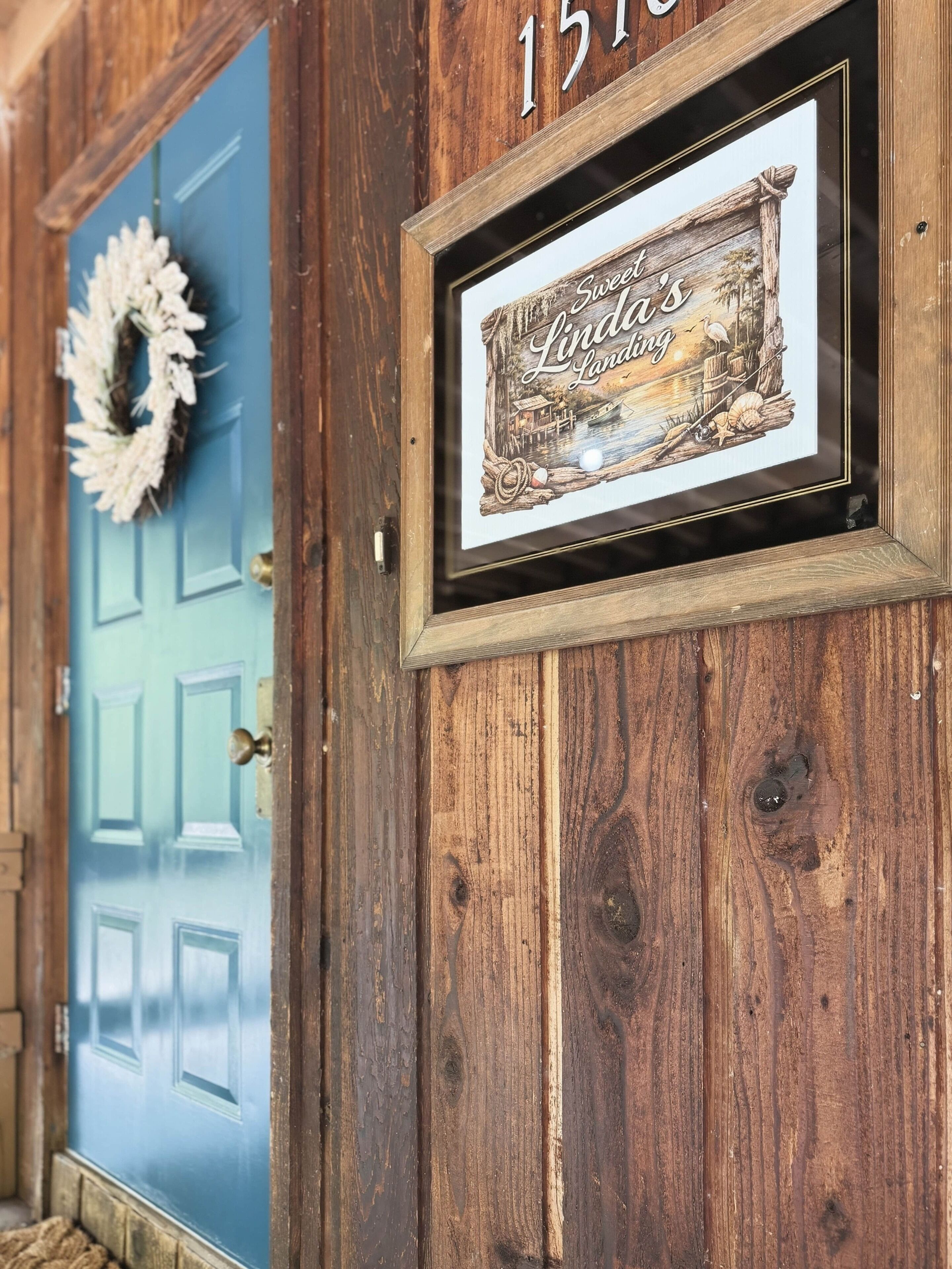 Una porta in legno con un pannello blu e il numero 151 sopra.