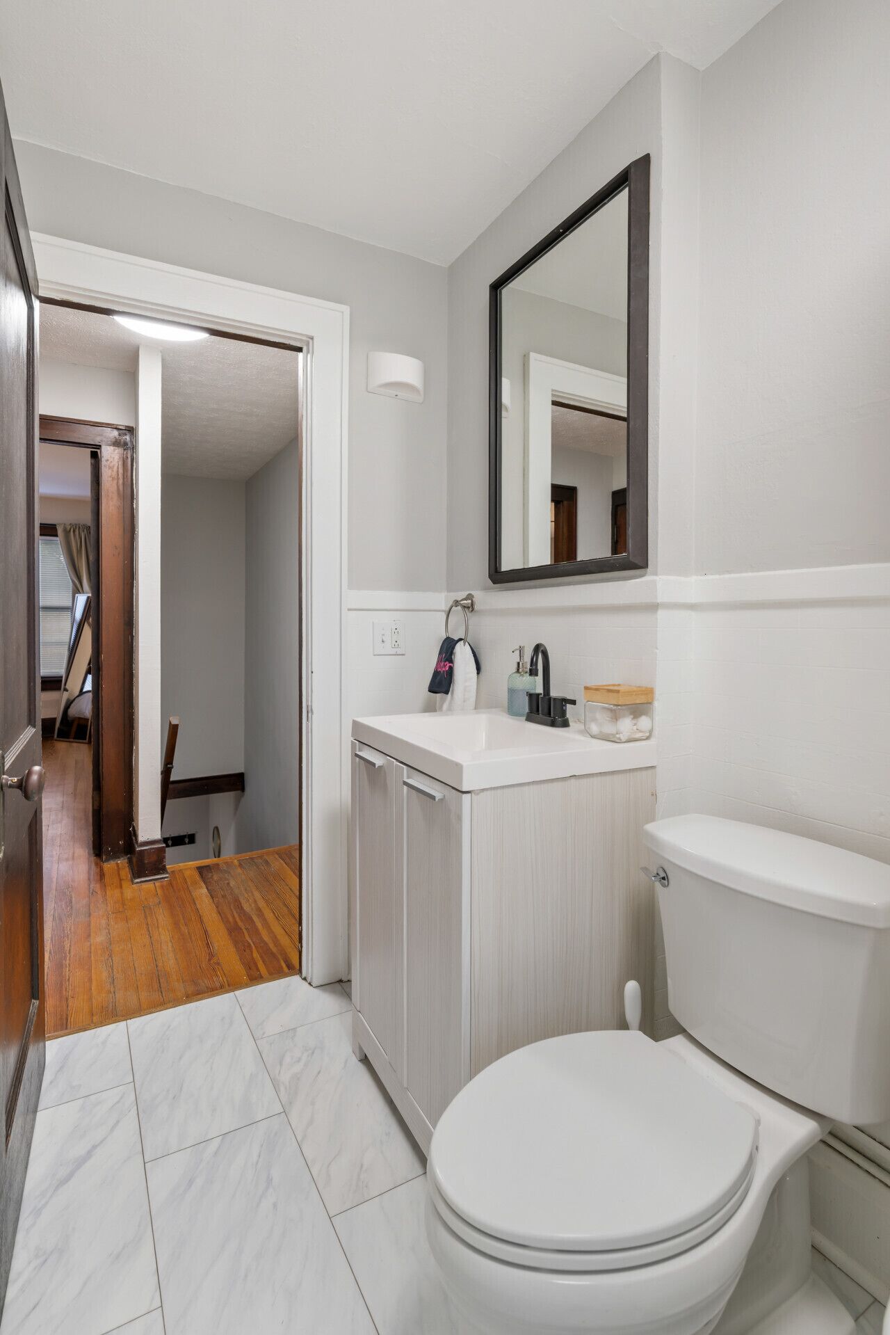 Un baño con inodoro, lavamanos y espejo.