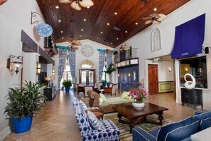 A spacious lobby with a high ceiling, wooden beams, and a seating area with sofas and a coffee table. - Paradise Palm Home Stay (Kissimmee)