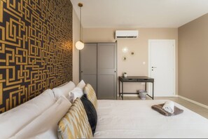 A bedroom with a patterned wall, a bed, a desk, and a door. - Luxury Penthouse Jacuzzi BBQ Terrace Pool Table (Xaghra)