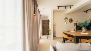 A modern dining area with a wooden table, chairs, and a sofa. - Luxury Penthouse Jacuzzi BBQ Terrace Pool Table (Xaghra)