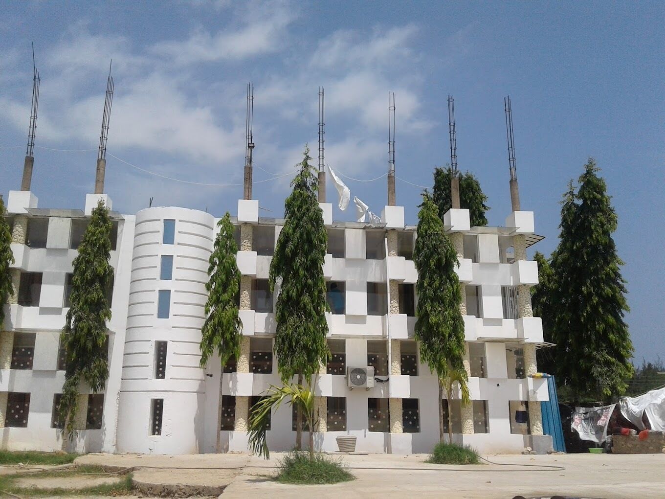 Un immeuble à plusieurs étages doté d’une architecture moderne, caractérisé par un mélange de formes rectangulaires et cylindriques.