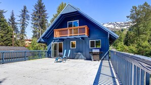 Ein blaues Haus mit Balkon, Grill und Terrass.