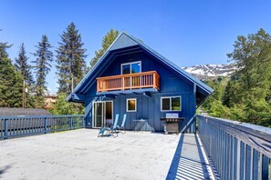 Una casa azul con balcón, una parrilla y una terraza.