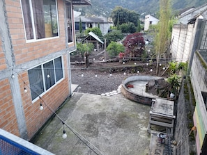 A courtyard with a brick building, a small garden, and a wooden fence.