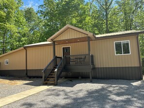 A single-story building with a wooden staircase leading to a covered porch. - Cozy 2-bedroom house in Nancy, 2 Miles From Wolf Creek Marina! Plenty of parking (Nancy)