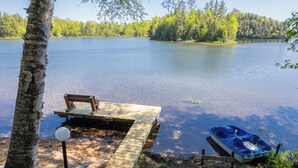 A wooden dock extending into a calm lake, surrounded by trees and a clear sky. - Straits Chilling: Sleeps 6*Pet Included*Hot Tub*Kayaks*Paddle Boat! (Wetmore)
