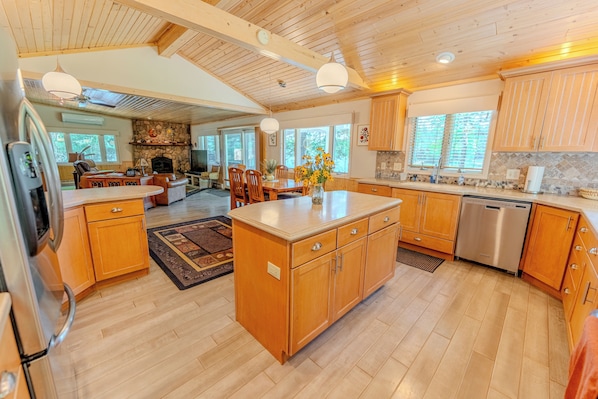 A spacious kitchen with wooden cabinets, a central island, and a dishwasher.