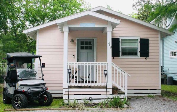 A small, single-story building with a porch, a door, and a mailbox.