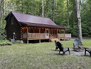 A log cabin with a porch, outdoor seating, and a fire pit. - North Haven Lodge | Shanty Creek | Pets | Bellaire (Bellaire)
