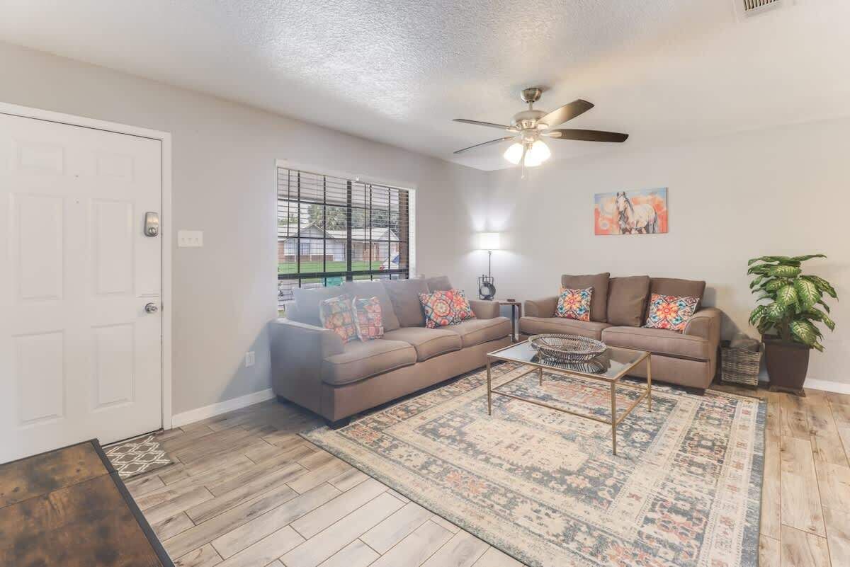 A living room with a sofa, coffee table, and a ceiling fan.