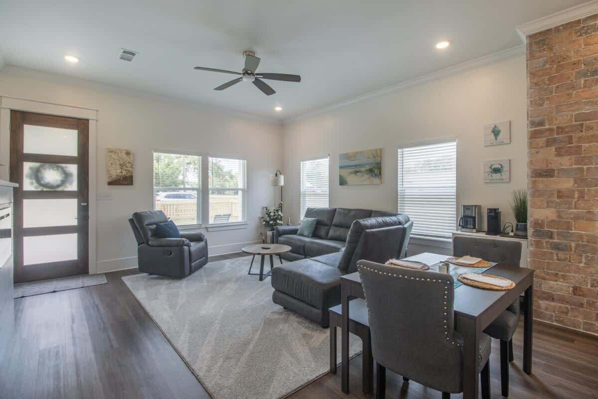 A spacious living room with a fireplace, a dining area, and a large window.