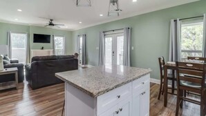 Un amplio espacio de sala con una isla de cocina, una mesa de comedor y un sofá.