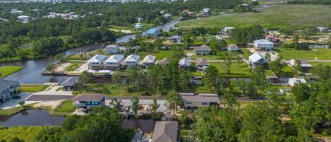 A residential area with houses, a river, and a distant shoreline.