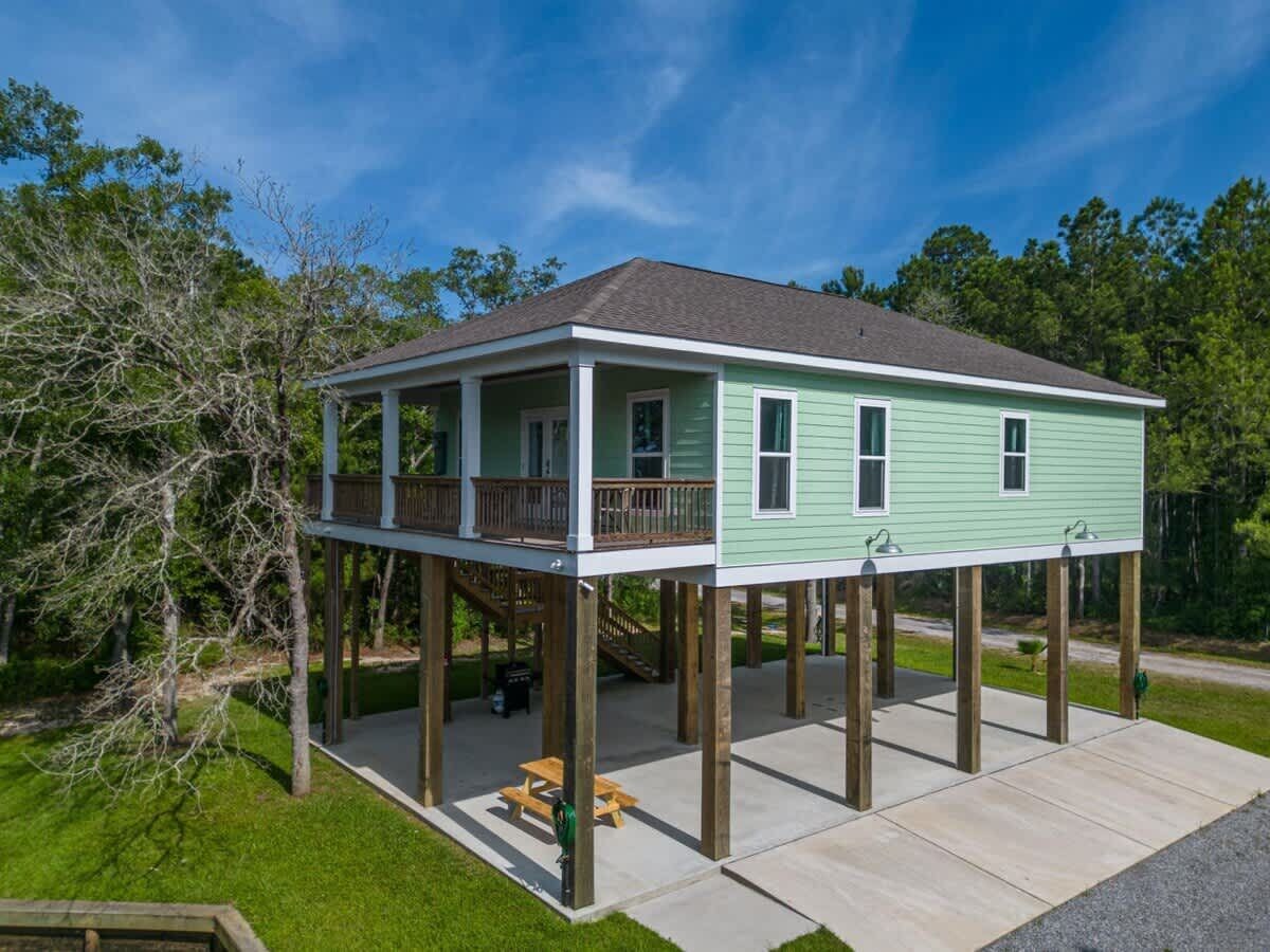 A two-story house with a covered porch and a deck.