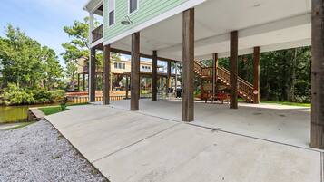 A covered outdoor area with a concrete floor, wooden pillars, and a view of a lake.