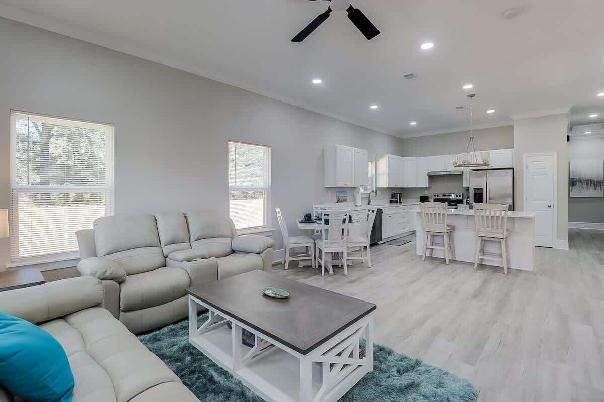 A modern living room with a sofa, coffee table, and dining area.