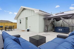 Eine überdachte Terrasse im Freien mit Essbereich, einem blauen Sofa und einem aufblasbaren Pool von Co-Z.