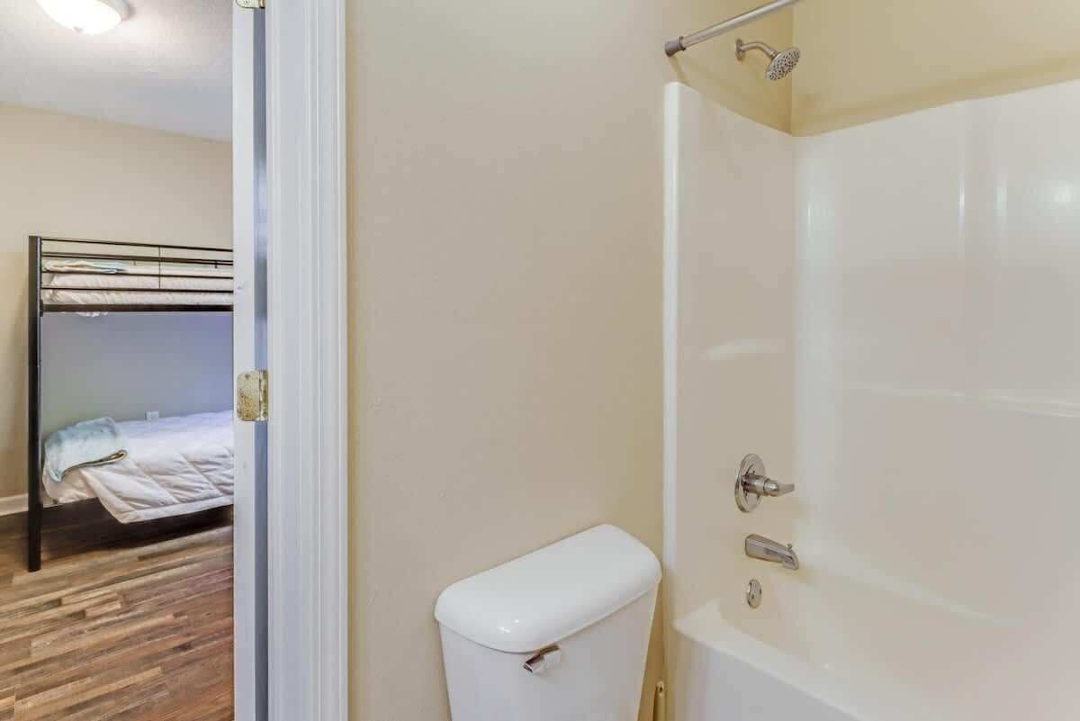 A room with a bed, a toilet, and a shower area.