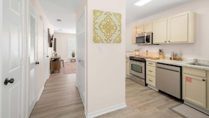 A kitchen with white cabinets, a microwave, and a dishwasher. - Cozy 2 Bed Duplex Just Blocks From Downtown Biloxi! (Biloxi)