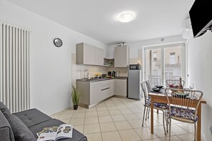 A modern kitchen with a dining area, a sofa, and a potted plant. - Casa Vergolano, Arco, Italy (Arco)