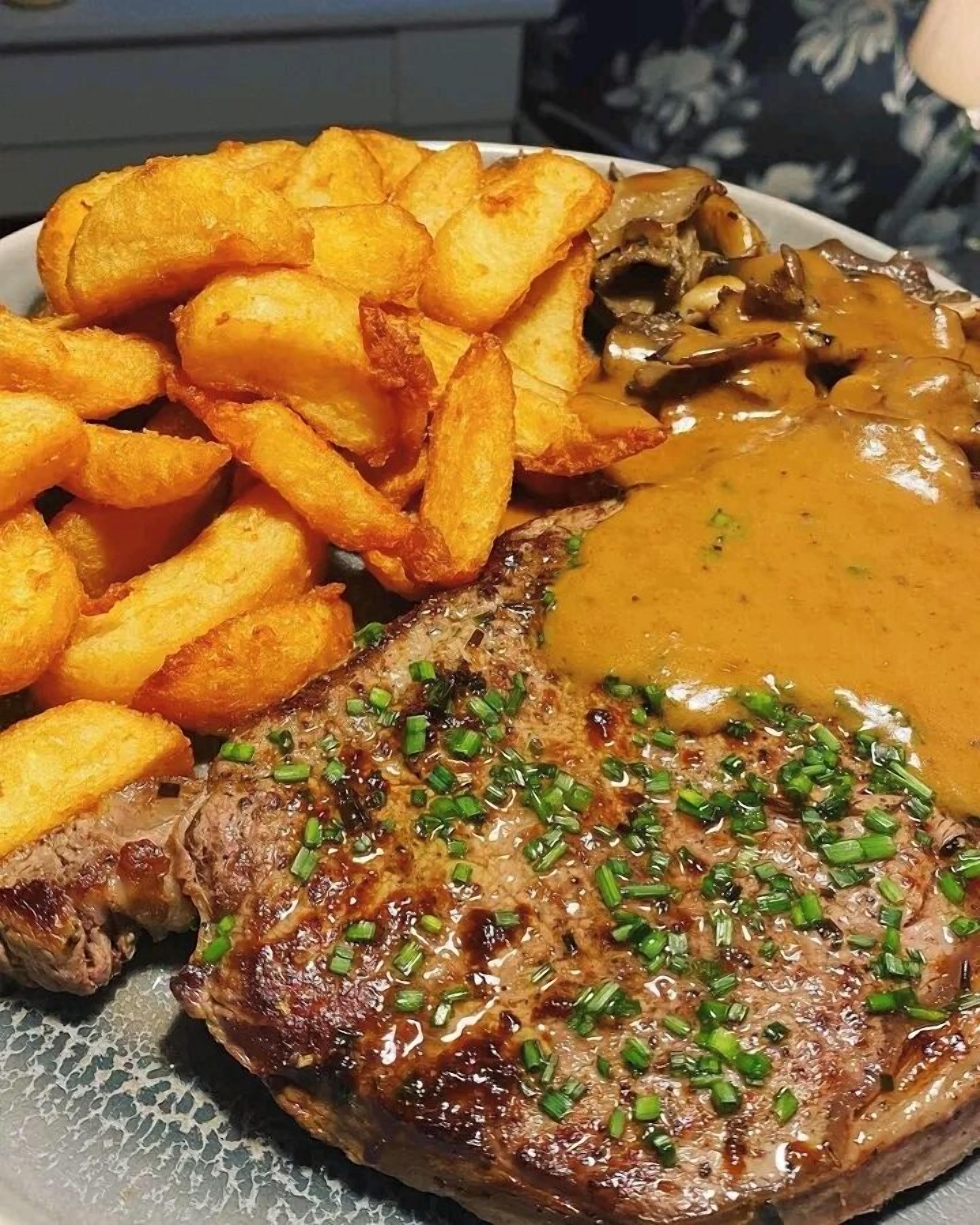 Um prato com bife, purê de batatas e cogumelos.