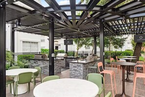 Un patio al aire libre con una parrilla, asientos y un letrero que dice Cortland.