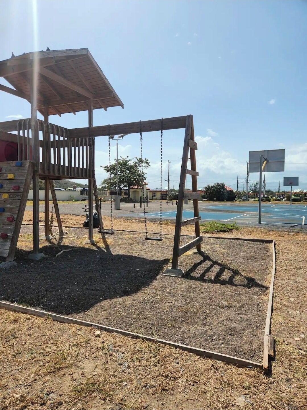 A playground with a swing set and climbing structure.