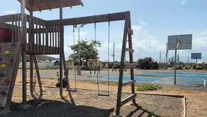 Ein Spielplatz mit Schaukeln und einer Kletterlandschaft.