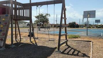 A playground with a swing set and climbing structure.