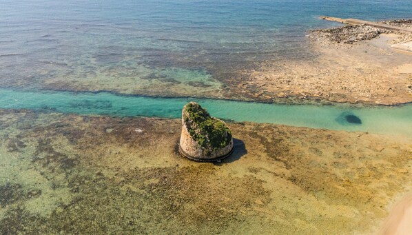 A coastal landscape with clear waters, a rocky outcrop, and a sandy beach. - Buena Vista - Sea Oasis Residence (Salve)