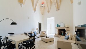 Amplia sala de estar con mesa de comedor, sillas, sofás y chimenea.