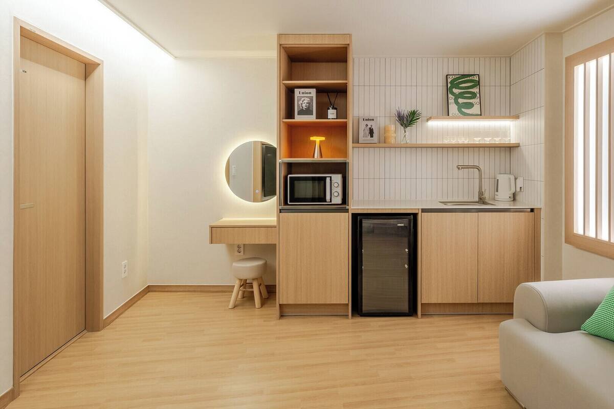 Eine kleine Küchenzeile mit Mikrowelle, Spüle und kleinem Kühlschrank.
