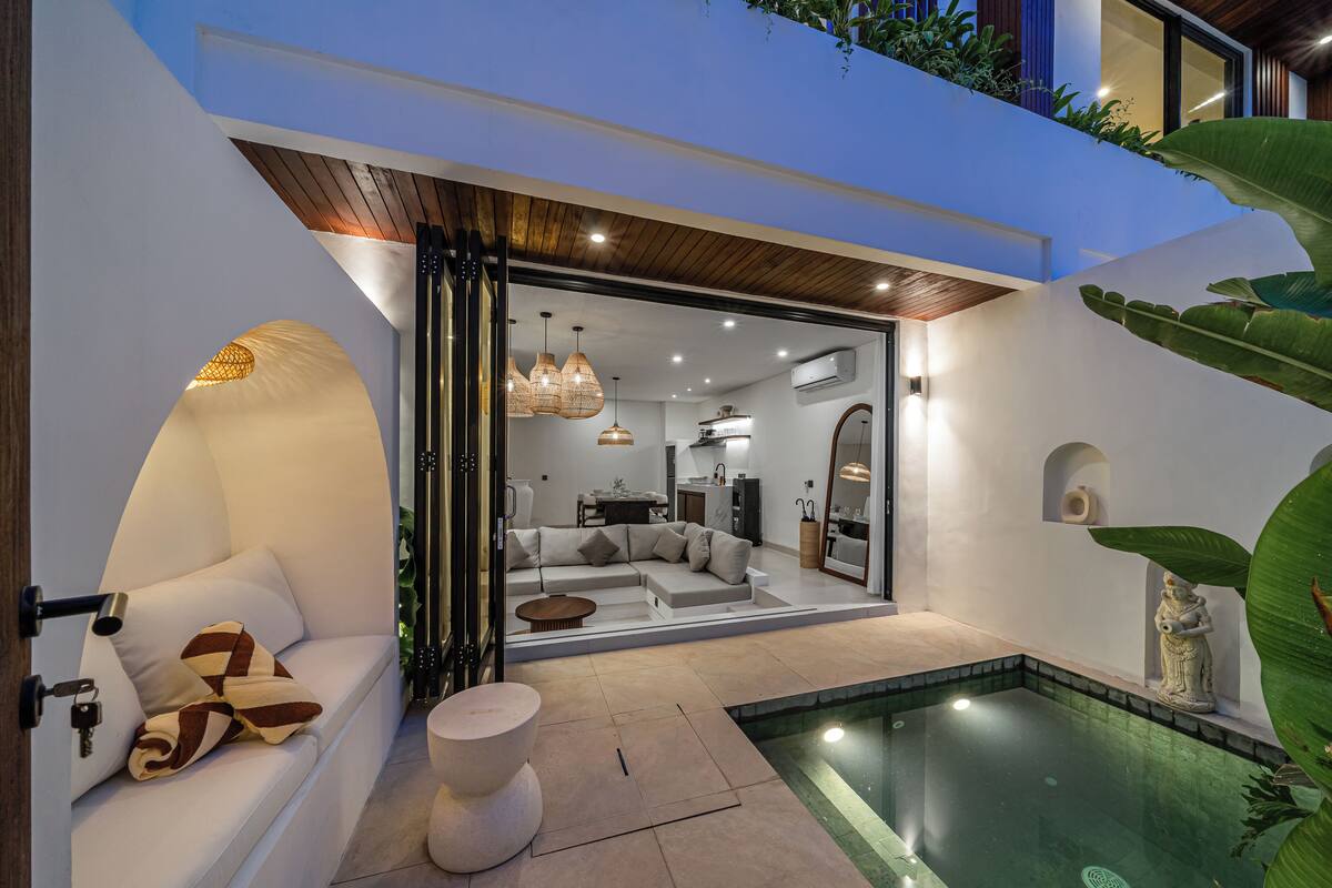 Un intérieur moderne avec une piscine, un coin salon et un espace repas.