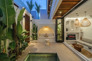 Un salón moderno con piscina, sofá y televisor mostrando el logotipo de Netflix.
