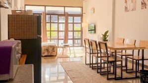 Una cocina moderna con comedor, ventanas amplias y un televisor de pantalla plana.