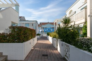 Un sentiero conduce a un edificio con facciata bianca e cielo azzurro.